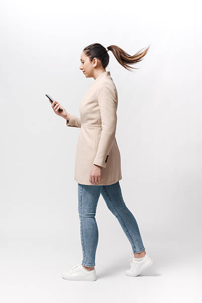 istock Young woman walking and checking her smartphone 2218403842