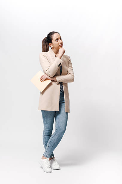Pensive woman standing and thinking with hand on chin
