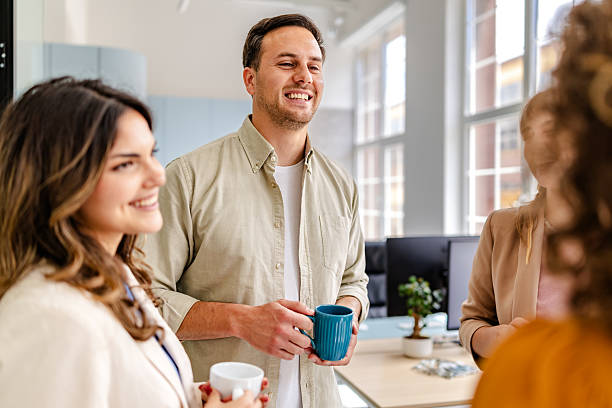 istock Colleagues engaging in a pleasant conversation while enjoying coffee in a bright, modern office space 2218403940