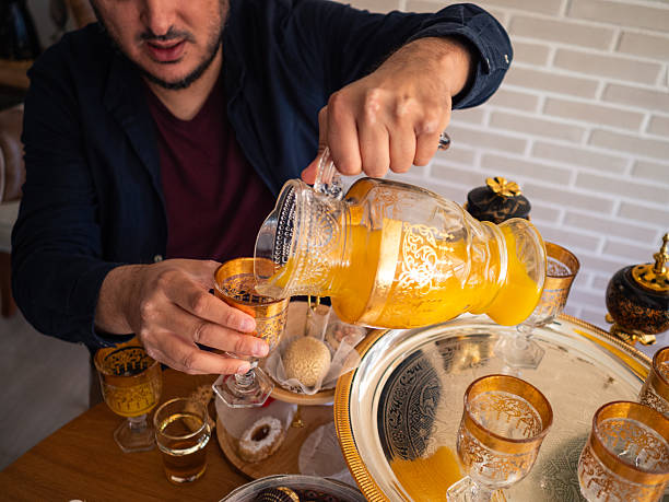 Orange juice pouring at an arabic festive gathering in a cozy home setting