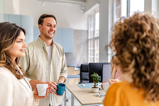 istock Coworkers engaging in lively conversation with drinks in a modern office setting promoting collaboration and enjoyment 2218404918