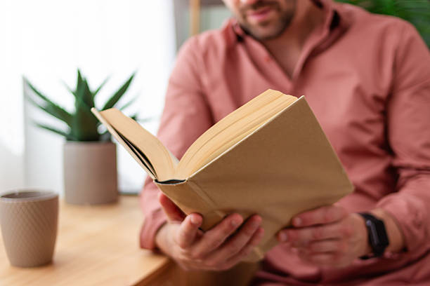 istock Man enjoying a book and relaxing at home 2218405329