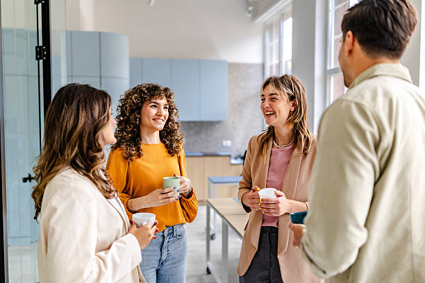 istock Group of colleagues enjoying a friendly discussion in a modern office setting with coffee cups 2218407177