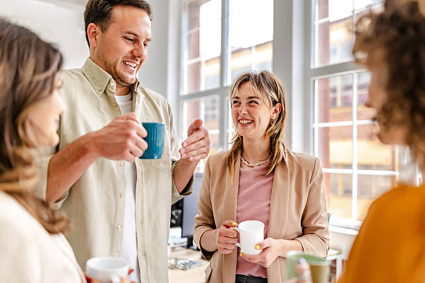 istock Group of professionals enjoying a coffee break in a modern office setting while discussing work-related topics and sharing laughs 2218407233