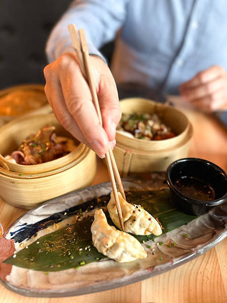 istock Japanese food: close-up hands holding chopsticks to pick up giozha 2218408160