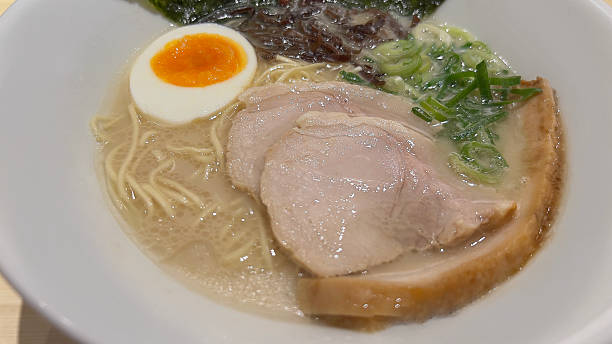 istock Authentic Tonkotsu Ramen with Chashu Pork, Soft-Boiled Egg, and Scallions in White Bowl 2218408865