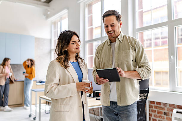 istock Professionals collaborate in a modern office environment, sharing ideas and enjoying each other's company during work hours 2218409444