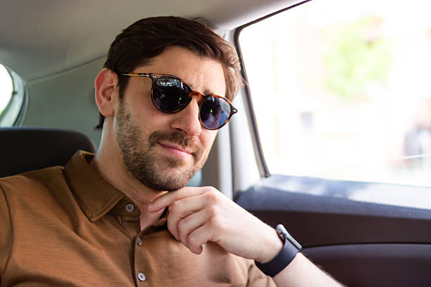 istock Young businessman adjusting his collar while sitting in a car 2218409677