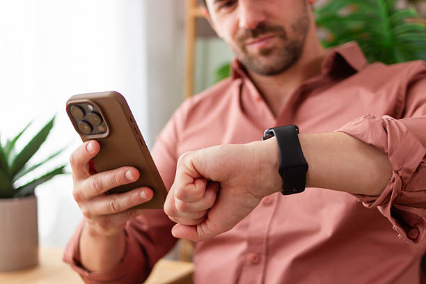 istock Businessman using smartphone and checking time on smartwatch 2218409819