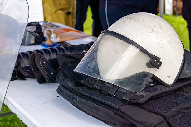 istock white helmet with a protective visor and a black tactical vest displayed on a table during a police equipment presentation. 2218410018