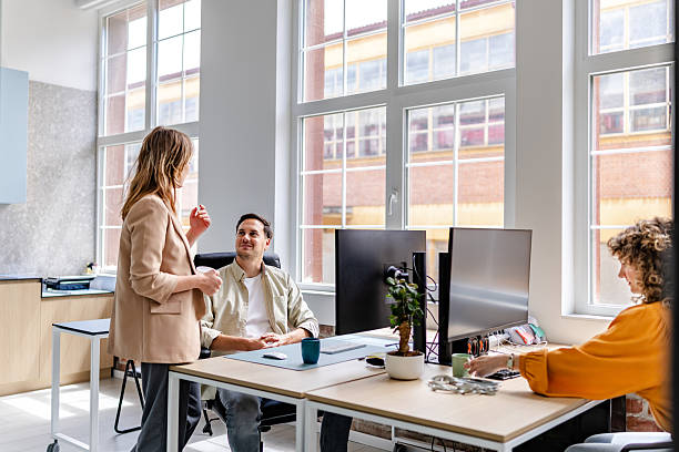 istock Professionals engaging in conversation and collaboration in a modern office environment with technology and bright natural light 2218410029