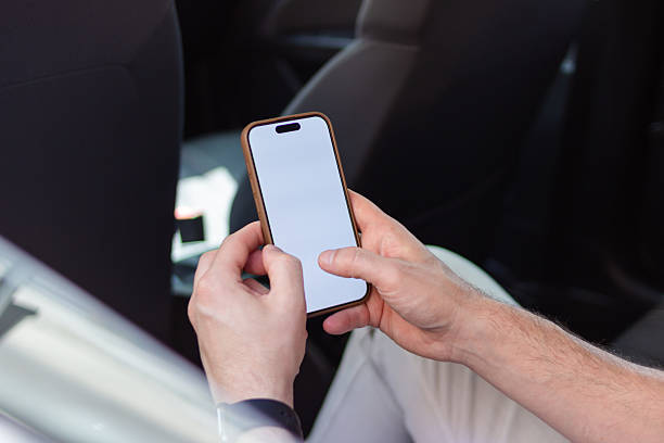 istock Businessman using smartphone with blank screen in car 2218410130
