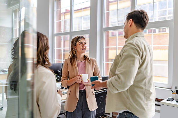 istock Team members engage in a joyful conversation in a modern office during the late afternoon 2218410729