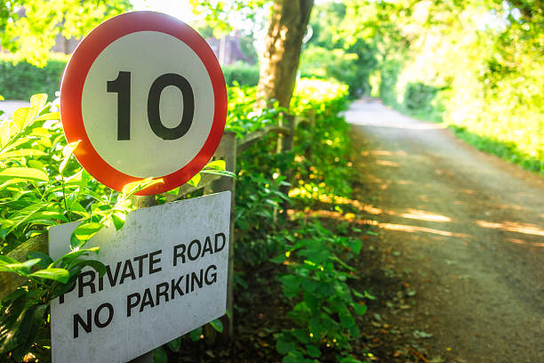 Close up color image depicting a 10mph speed limit sign on a narrow private road in rural West Sussex, UK.