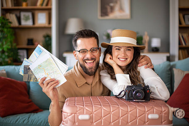 istock Happy couple planning summer vacation with maps and suitcase 2218417043
