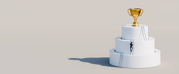 istock Man climbing ladders leaning against concentric cylinders up to golden trophy as the final goal. Career, competition, corporate ladder concept. Web banner format with copy space 2218417531