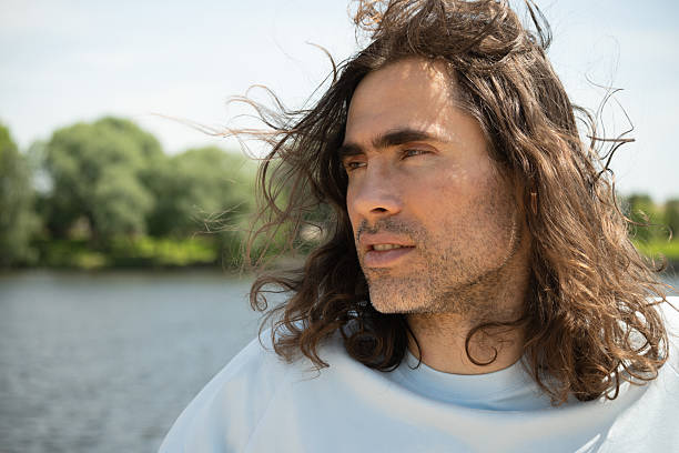 istock Thoughtful Man with Long Hair by a River 2218419691