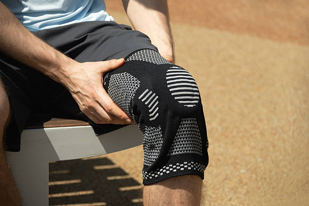 istock Knee support brace on male legs outdoors in summer. 2218420905