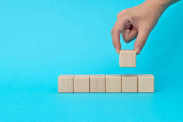 istock Wooden blocks in a row on blue background 2218422302