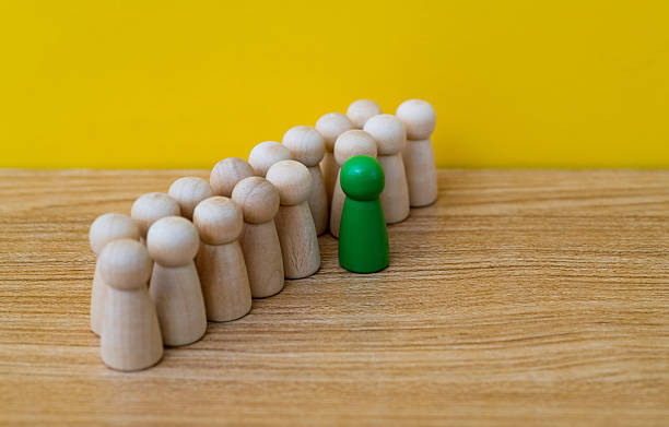 istock Green one standing out from the wooden figures 2218422891