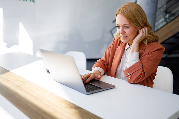 istock Smiling businesswoman using laptop, enjoying work in modern office, focused on task, professional in workspace 2218424477