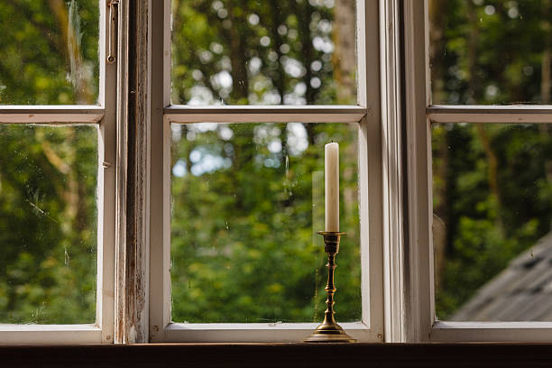 istock Old vintage window and vertical candle in candlestick 2218427283