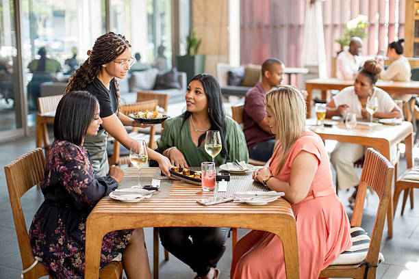 waiters delivering asian food orders in a restaurant - アフリカ 食事 ストックフォトと画像