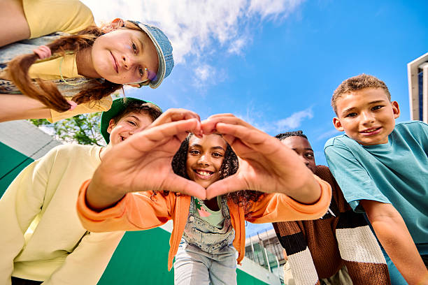 istock Group of school children making heart shape with hands 2218431013