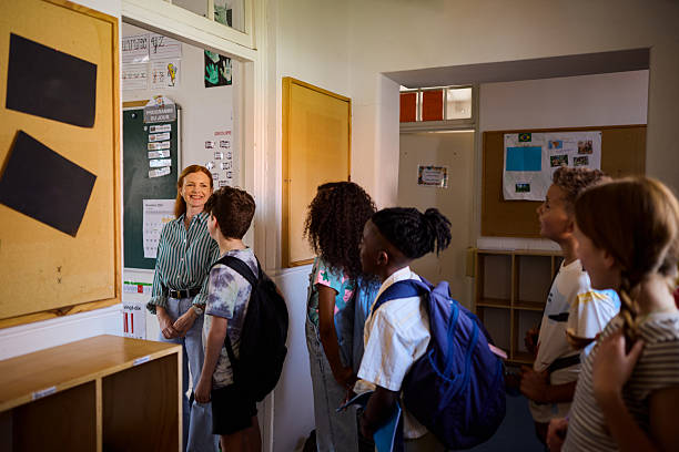istock Teacher welcoming elementary age students at classroom doorway 2218431041