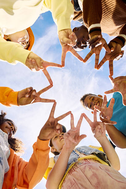 istock Group of school students making star shape with fingers 2218431042