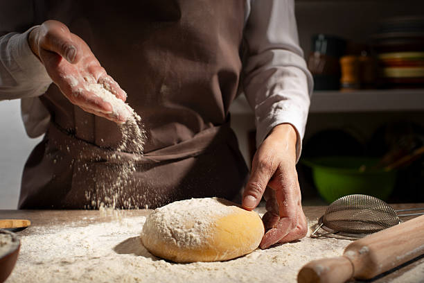 istock Baking concept. Caucasian female hands throwing flour at the dough. 2218431464