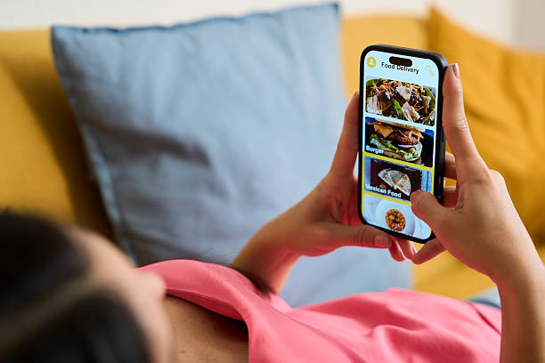 istock Woman relaxing on sofa using food delivery app on smartphone 2218434554
