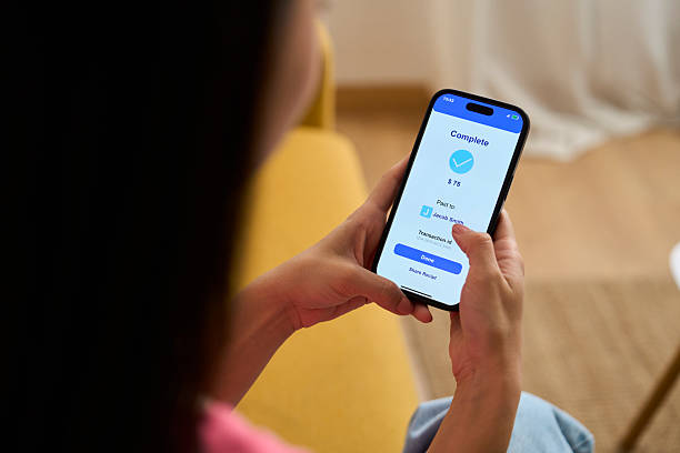 istock Woman completing mobile payment on smartphone app at home 2218434842