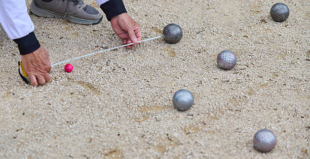 istock A player measures the distance between boules and the jack on a petanque court using a measuring tape during a competitive match 2218435159