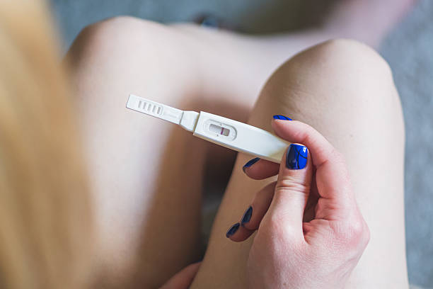 istock Young blonde girl with pregnancy test 2218435180
