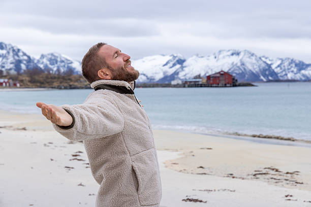 istock Man Enjoying Peaceful Beach with Mountain View 2218435648