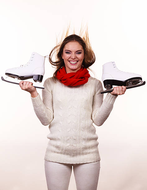 Winter skate sport people concept. Crazy girl with ice skates. Young woman has white outfit and long beutiful hair.