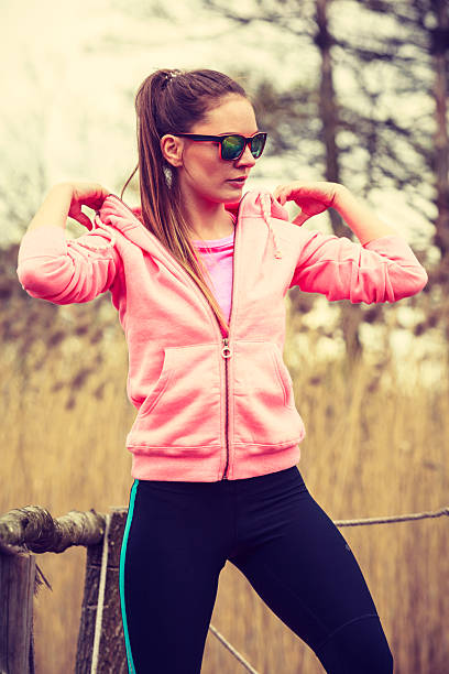 Sport and lifestyle concept. Young sports woman female jogger taking a break from running workout, relaxing on pier on sunny day