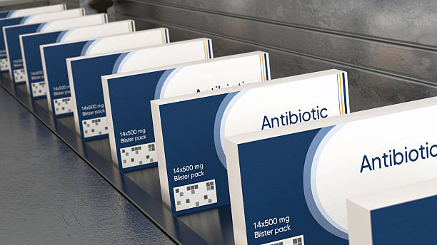An overview of the packaging process for antibiotics in a high-tech pharmaceutical plant. Observers can see the assembly line efficiently sealing boxes and labeling products.
