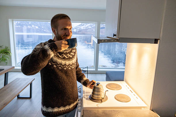 Man Enjoying Hot Beverage by Scenic Lake View in Cozy Cabin