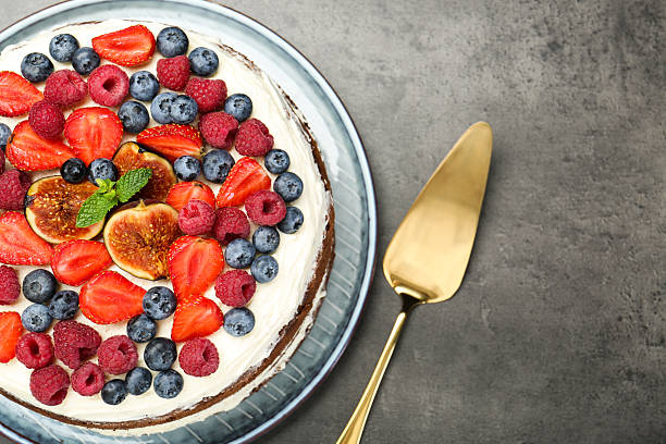 istock Delicious chocolate sponge cake with berries and server on grey table, top view 2218443550