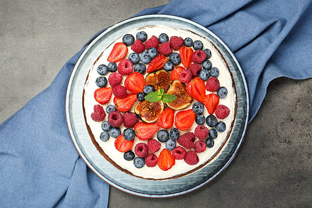 istock Delicious chocolate sponge cake with berries on grey table, top view 2218443555