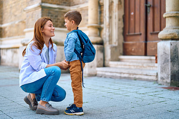 istock Mother Holding Her Son's Hand Before School 2218444534