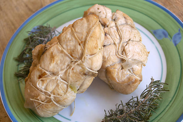 istock two chicken breasts tied with kitchen twine resting on plate with rosemary garnish 2218444592