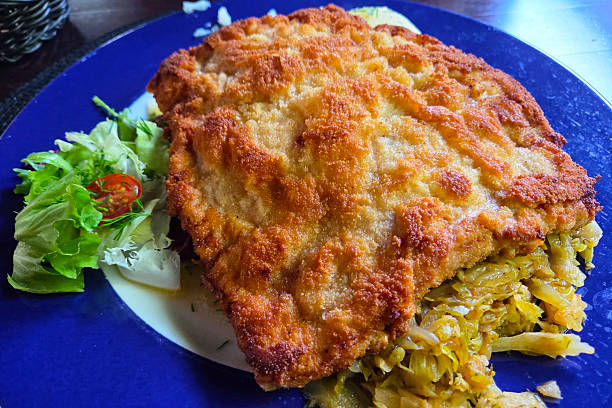 istock Crispy Breaded Schnitzel with Fresh Salad on Blue Plate for Culinary Presentation 2218449907