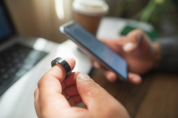 Man with smart ring and smartphone indoors