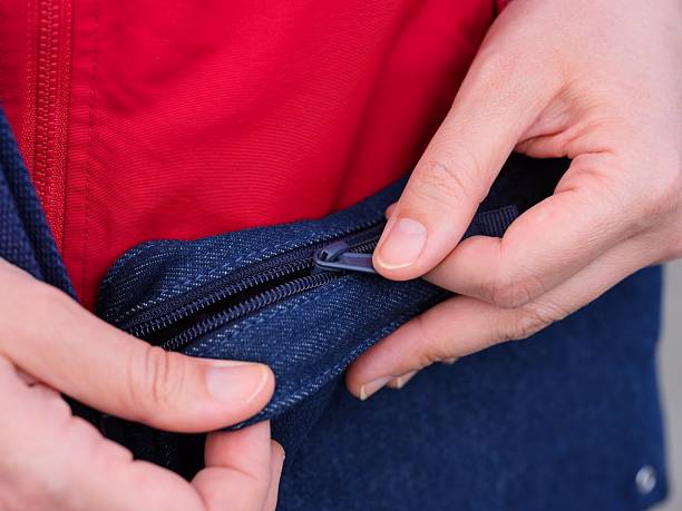 istock Woman pulling up the zip to open her denim bag. 2218452140