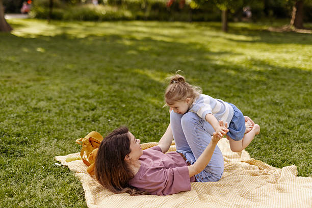 istock Happy Mother and Daughter Playing on Blanket in Park 2218452875