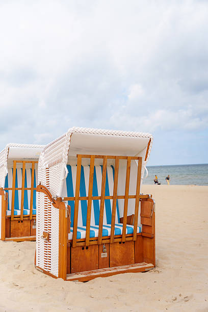 istock Classic beach chairs invite relaxation by the Baltic Sea on a sandy coastline under a cloudy sky promising vacation bliss and leisure time for enjoying the peaceful coastal scenery 2218453523