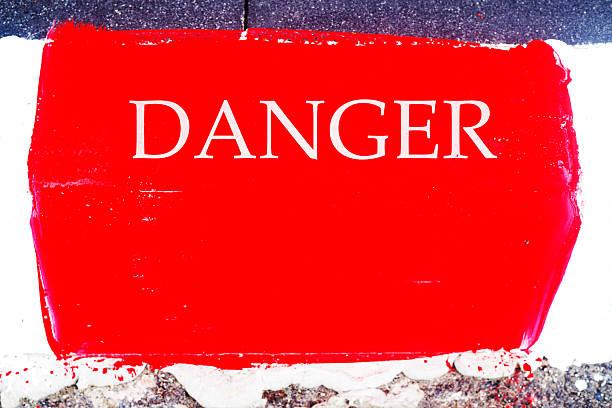 Letters Danger on red sidewalk border stone